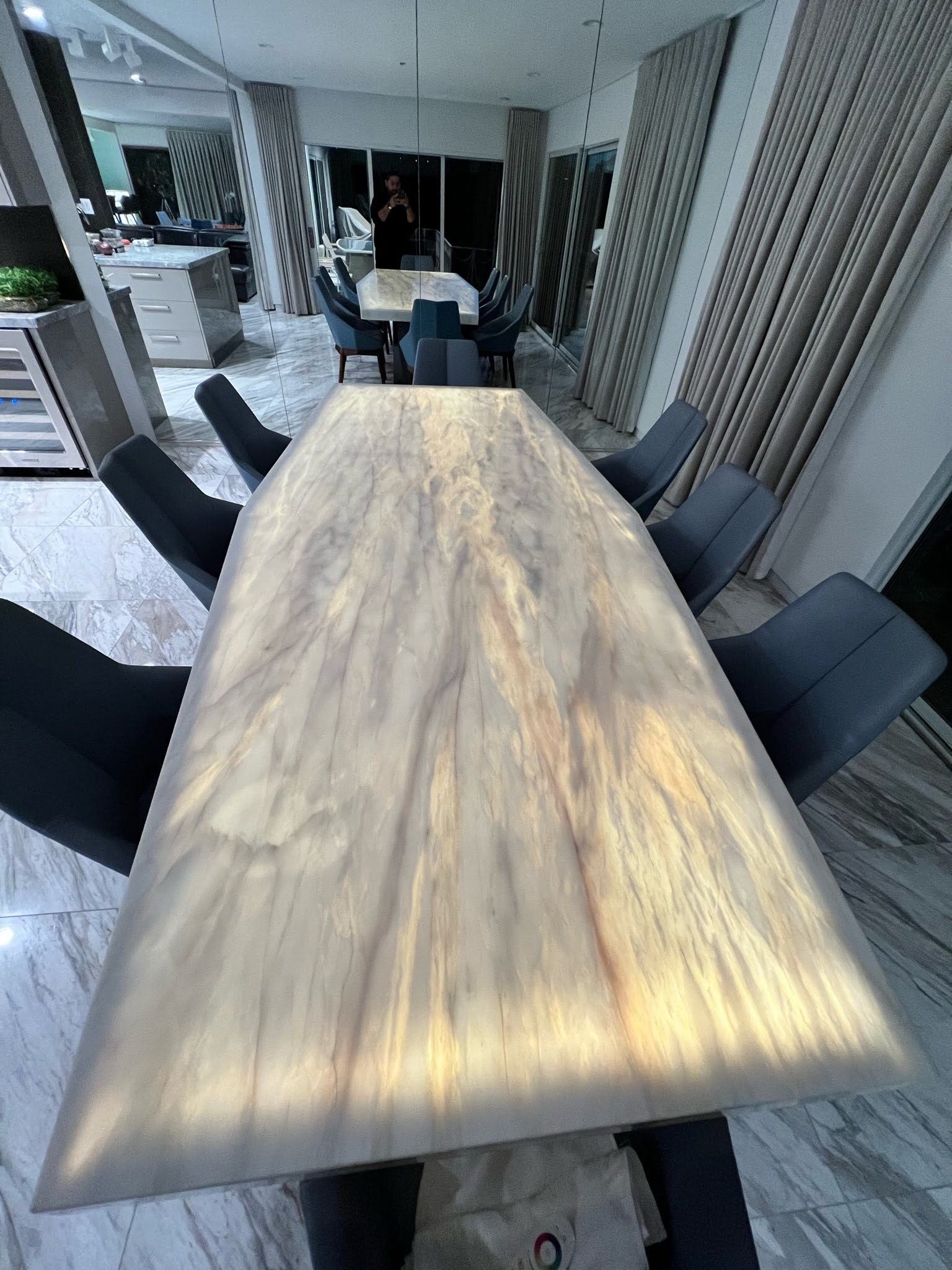 Backlit translucent onyx dining table with full-slab vein structure and tuned color temperature by LIT Group.