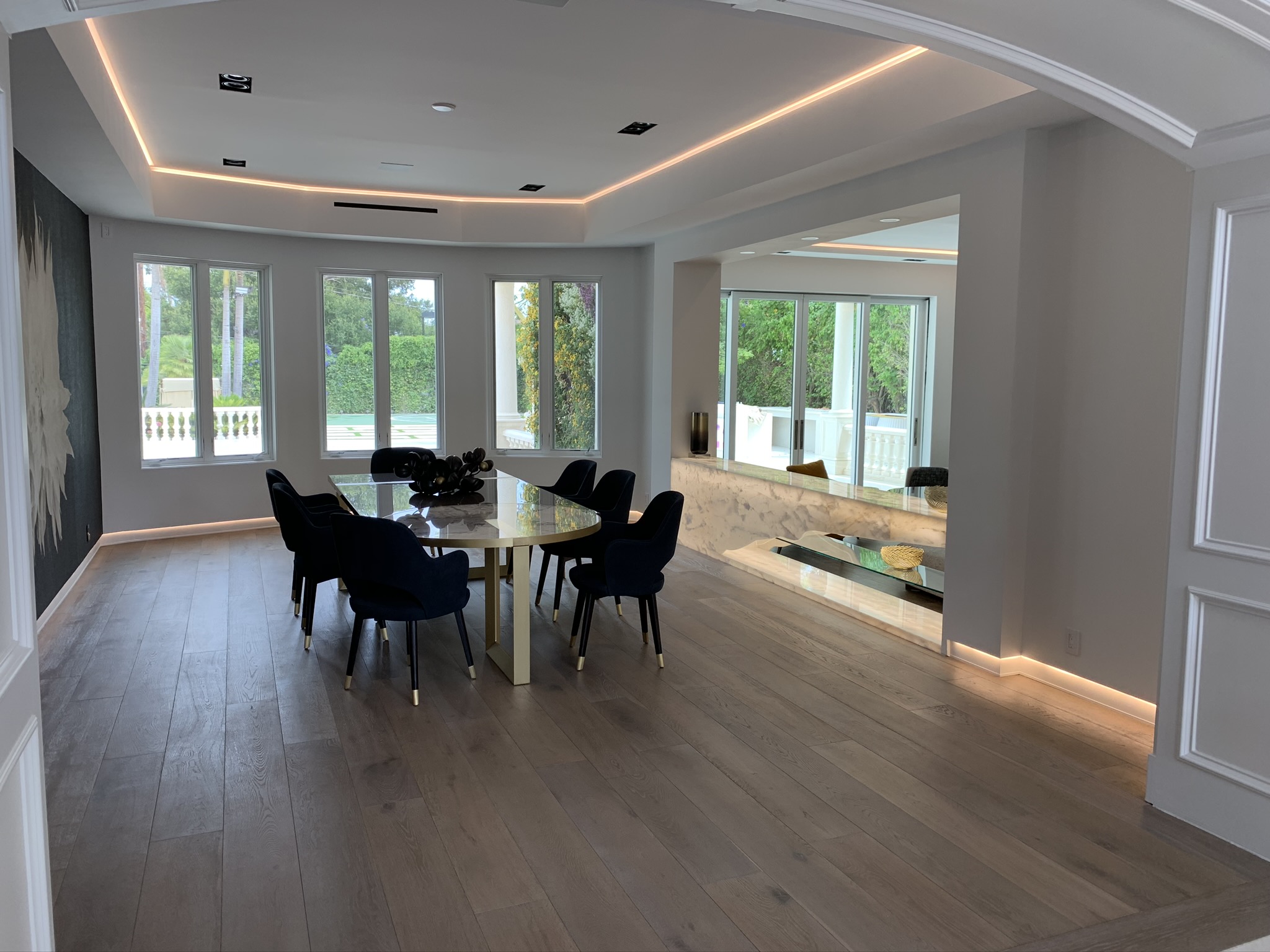 Concealed cove lighting in a tray ceiling above a luxury residential dining room by LIT Group.